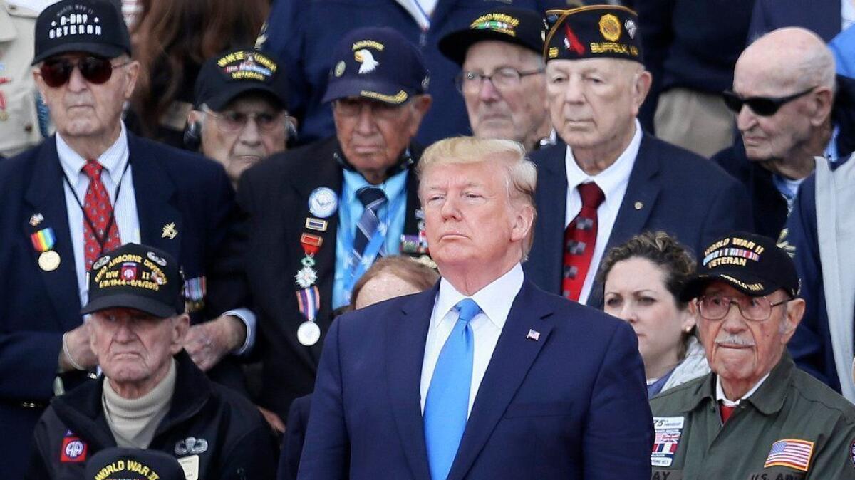 President Trump stands in front of World War II veterans during a ceremony to mark the 75th anniversary of D-day at the American cemetery in Colleville-sur-Mer, France, on June 6.
