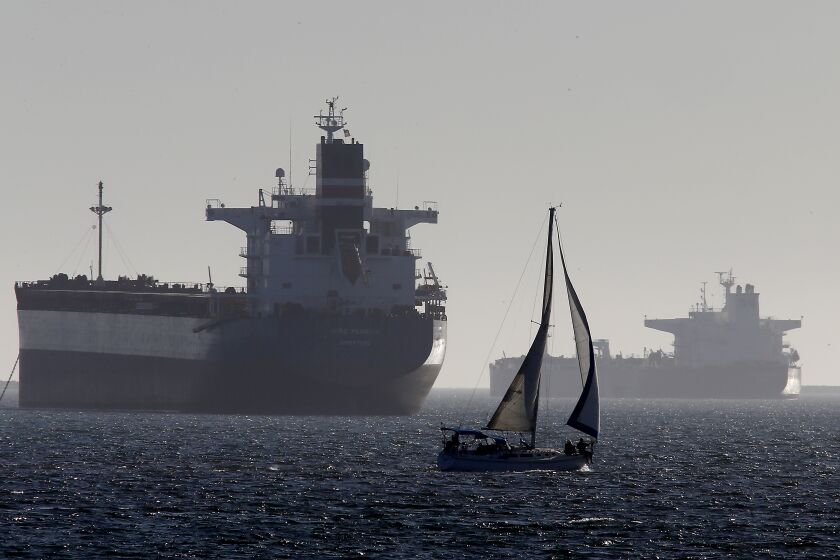 LONG BEACHH, CALIF. - APR. 22, 2020. Boaters navigate past oil tankers anchored off Long Beach on Wednesday, Apr. 22, 2020. Due to a nearly worldwide economic shutdown because of the coronavirus pandemic, there is currently a glut of crude oil and markets have dropped to below zero dollars per barrel. (Luis Sinco/Los Angeles Times)