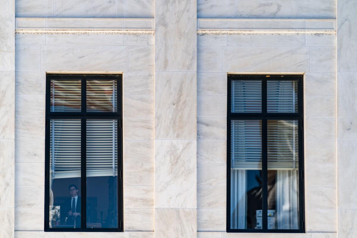An American flag and the U.S. Capitol Building reflected in windows 