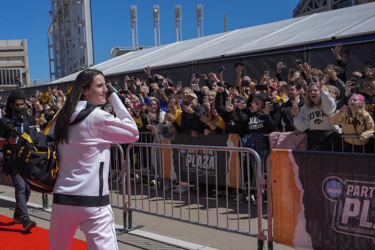 Fans cheer as Iowa's Caitlin Clark arrives for the NCAA women's championship basketball game against South Carolina.