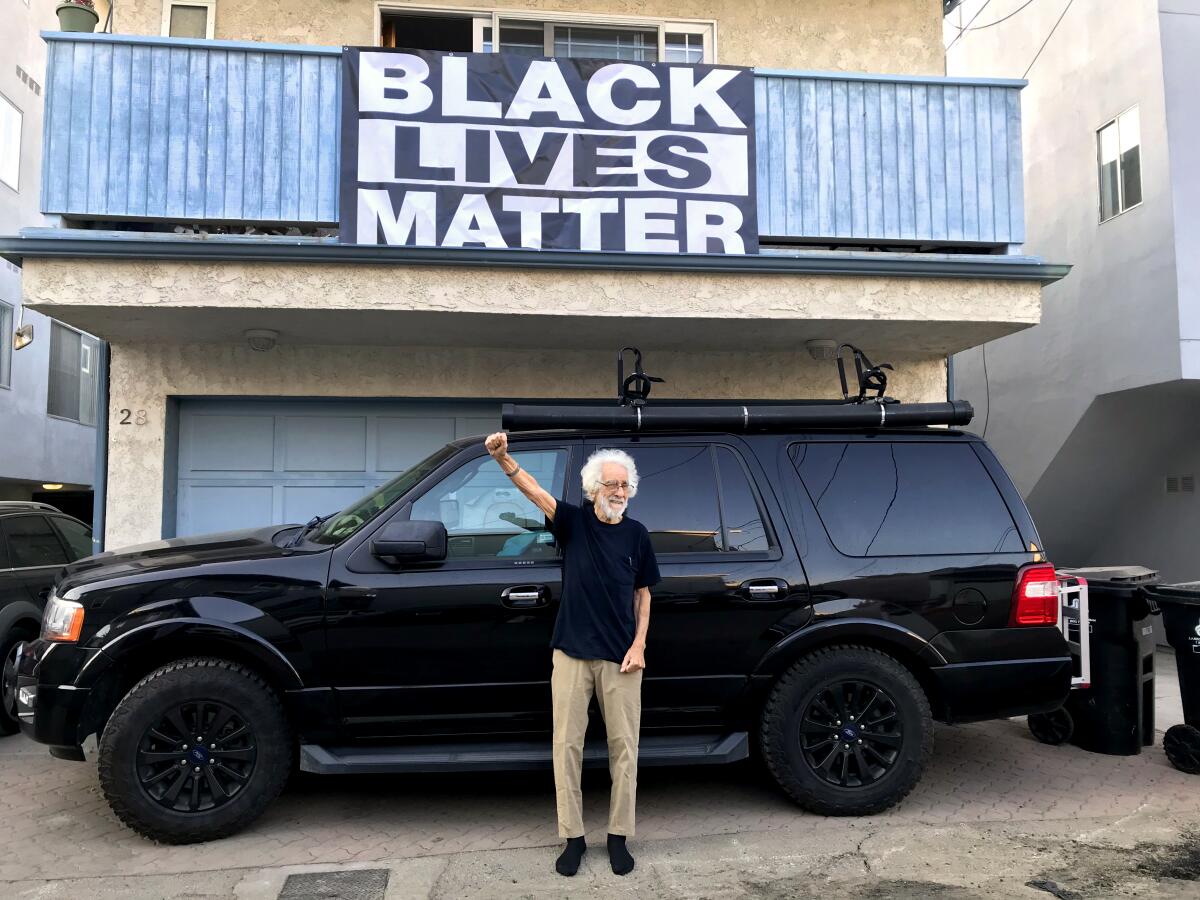 Robin Abcarian's father Richard Abcarian raising a fist in front of a Black Lives Matter banner. 