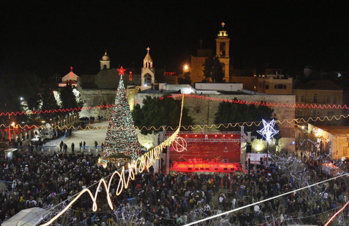 Christian pilgrims and and tourists celebrate Christmas Eve at Manger Square in front of the Church of the Nativity in Bethlehem.