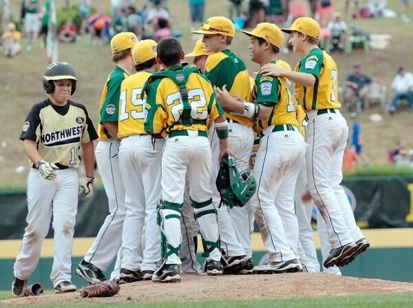 Pearce Kurth of Billings, Mont., walks past Ocean View players celebrating their 11-2 victory in the U.S. championship game on Saturday at the Little League World Series.