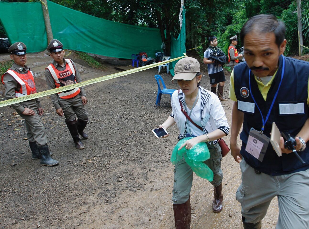 A relative of one of the trapped boys goes to meet with officers during the rescue operation Sunday at Tham Luang cave.