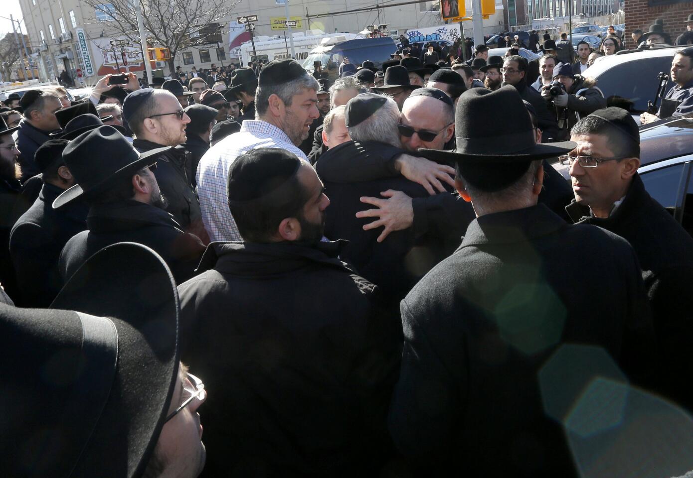 Mourners embrace each other after funeral services for the seven siblings killed in a house fire on March 22, 2015, in Brooklyn.