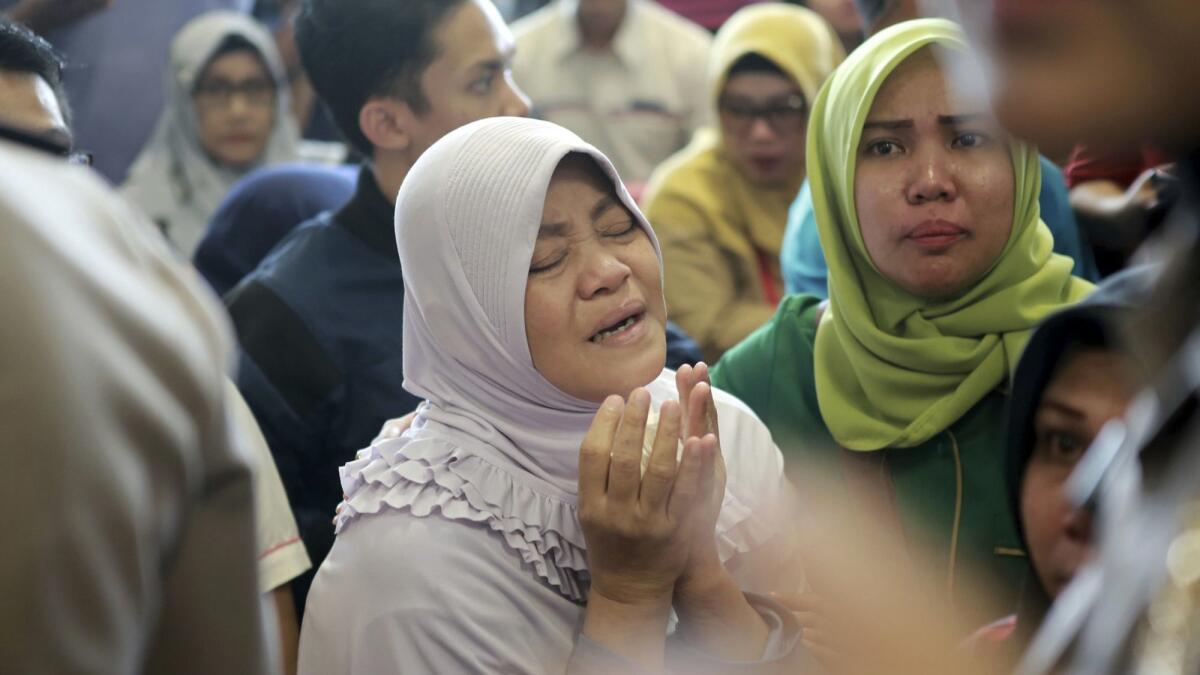 A woman prays as she and others wait for news on a Lion Air plane that crashed off Java at Depati Amir Airport in Pangkal Pinang, Indonesia, on Oct. 29.