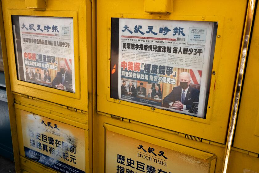 Epoch Times are for sale in sidewalk newspaper boxes, Monday, Feb. 8, 2021, during the coronavirus pandemic in the Chinatown neighborhood of New York. (AP Photo/Mark Lennihan)