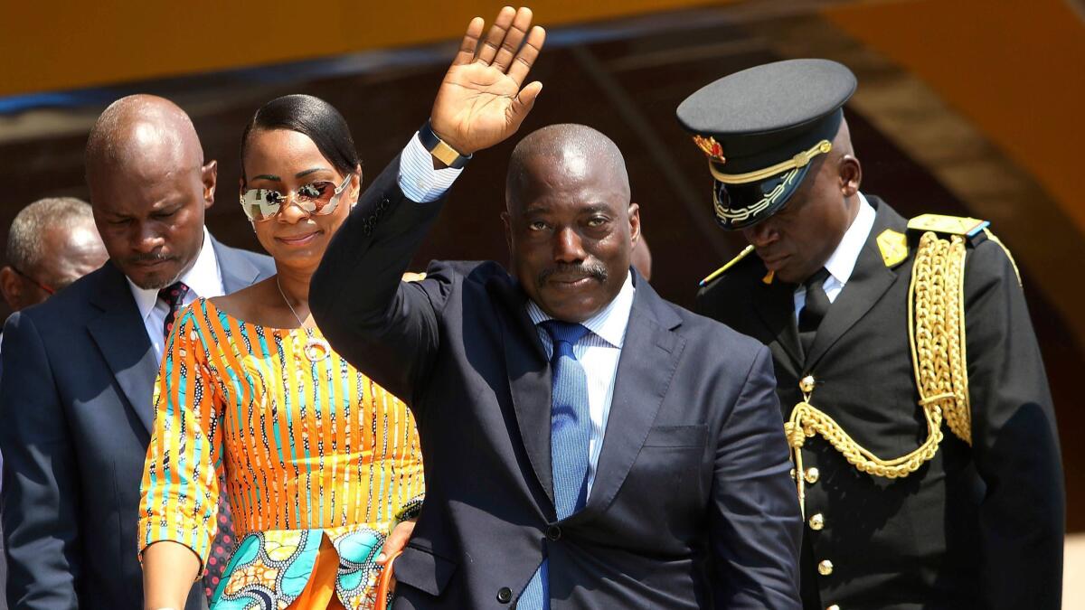 Congolese President Joseph Kabila waves as he and others celebrate independence day for the Democratic Republic of Congo in Kindu on June 30, 2016.