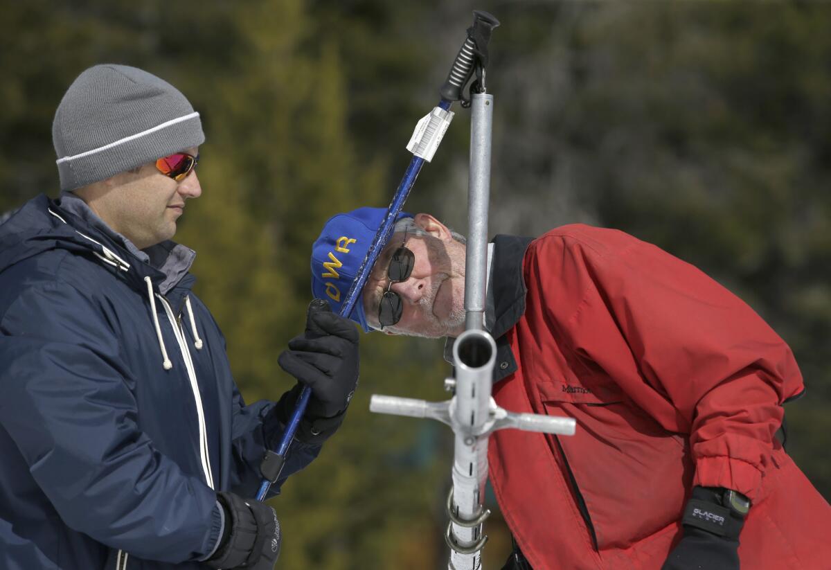 Frank Gehrke, right, chief of the California Cooperative Snow Surveys Program for the Department of Water Resources, checks the weight of the snowpack on a scale held by Brian Brown of the Legislative Analysts office during a manual snow survey Tuesday at Phillips Station near Echo Summit, south of Lake Tahoe.