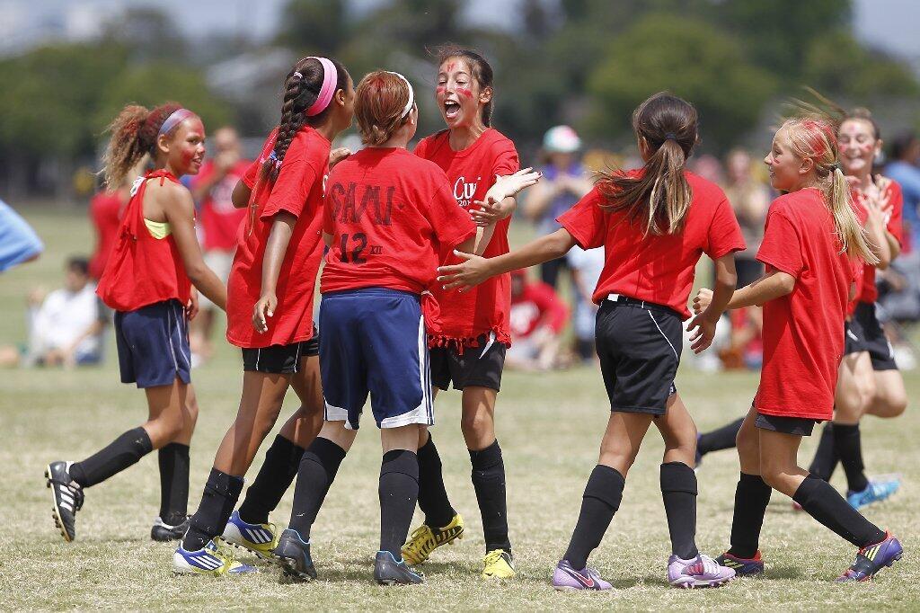 Members of the Kaiser team celebrate a goal during the girls' 5-6 gold division championship game against Andersen at the Daily Pilot Cup.