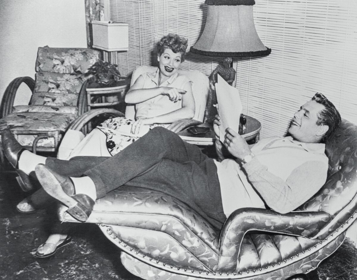 A woman and a man sitting and laughing in a living room
