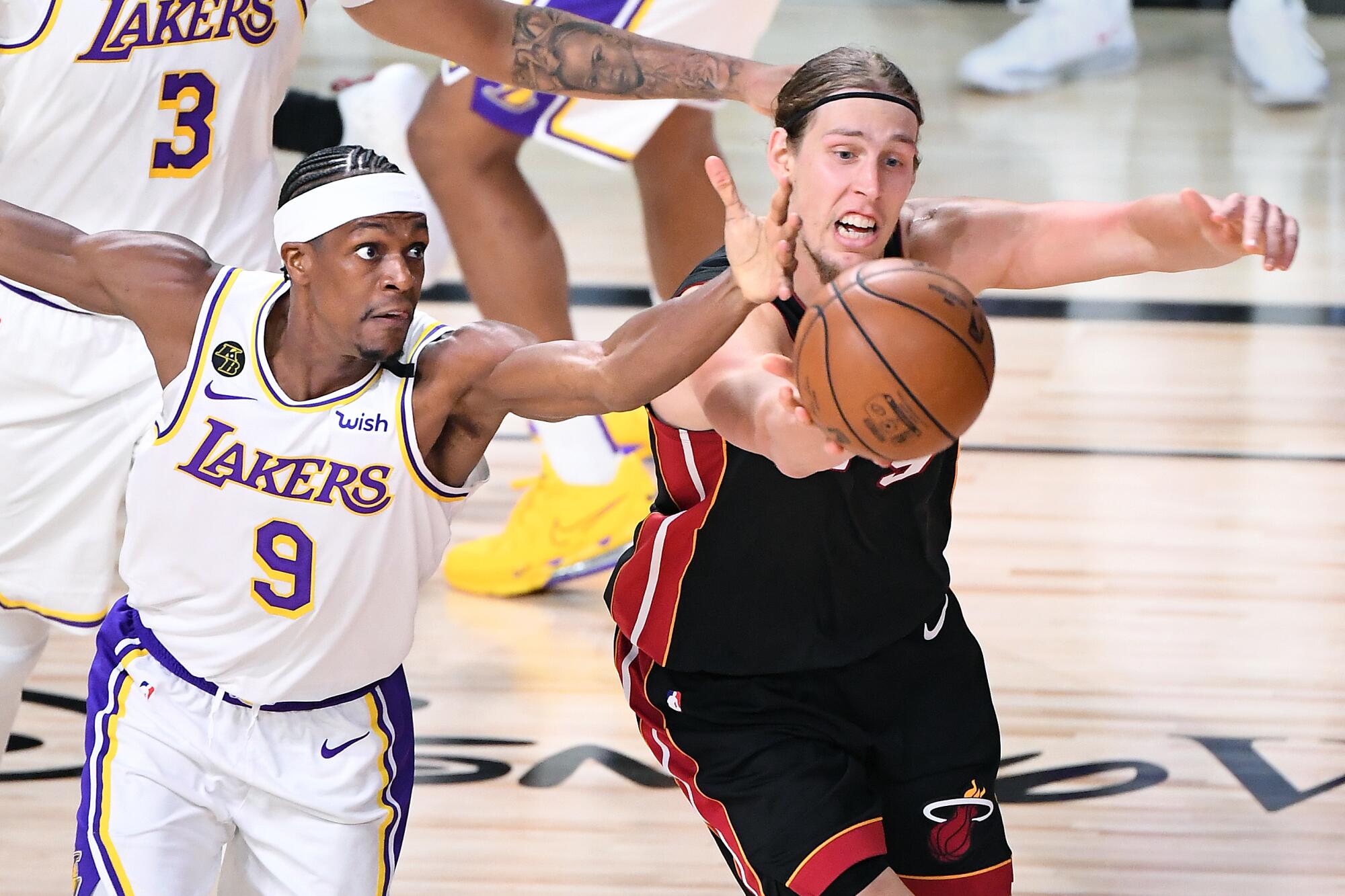 Lakers guard Rajon Rondo and Heat center Kelly Olynyk chase after a loose ball during Game 3 on Sunday night.