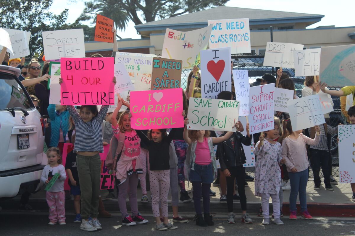 Cardiff School families hold protest signs.