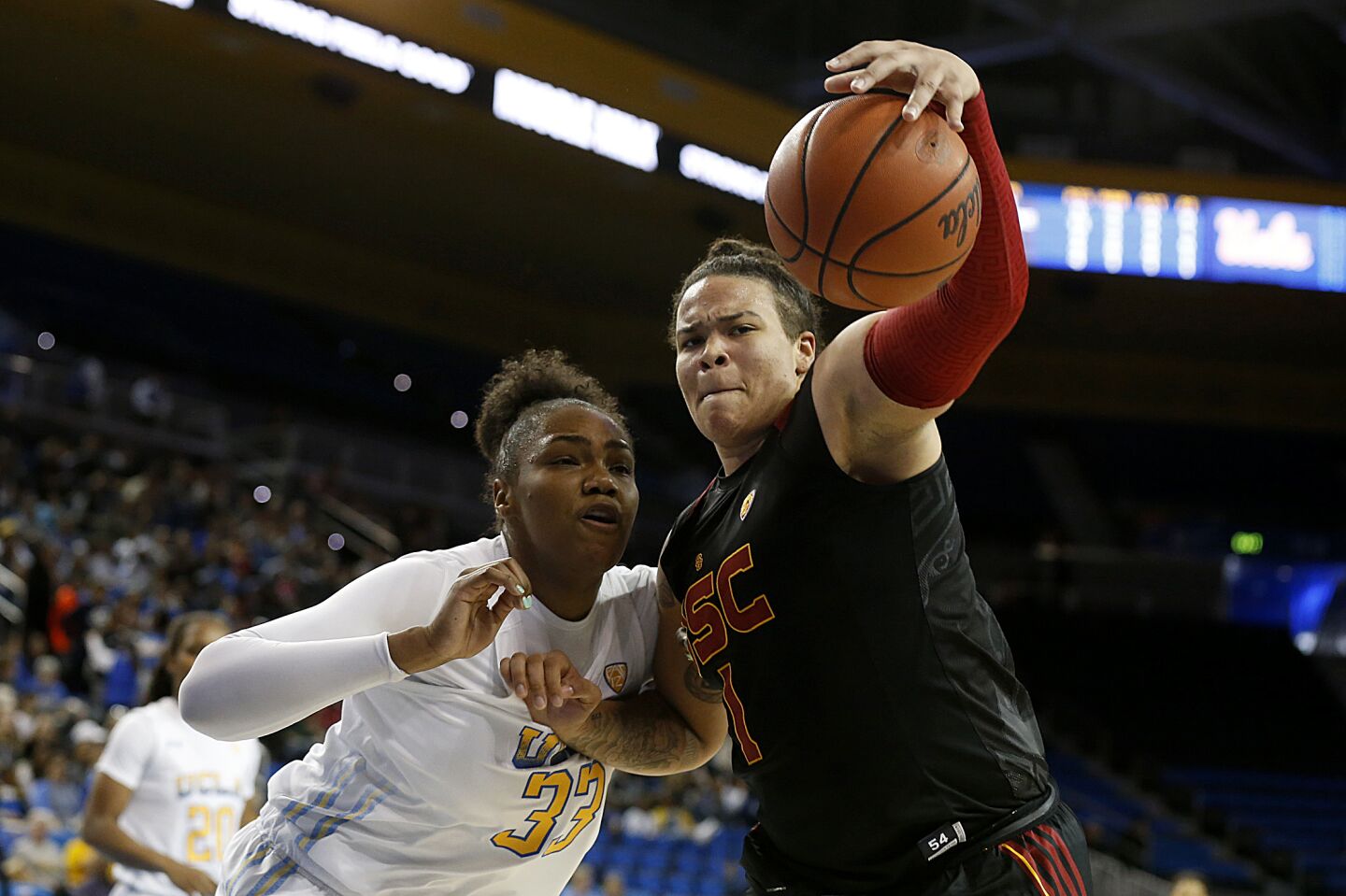 UCLA forward Lauryn Miller (33) and USC forward Kayla Overbeck (1) fight for a loose ball during the first half.