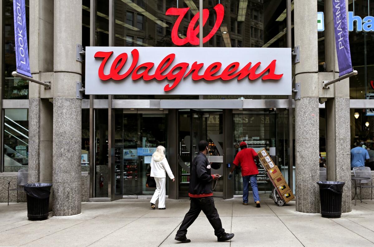 People walk in to a Walgreens retail store in Boston. 