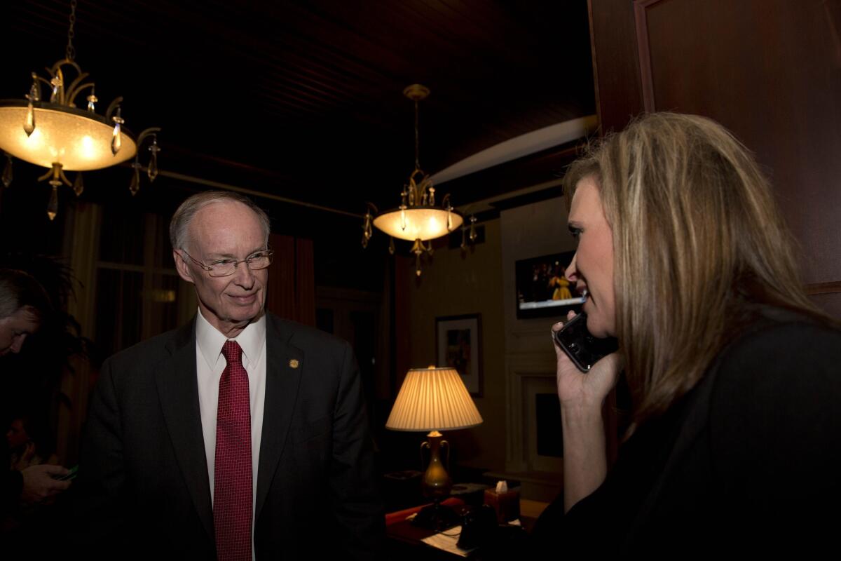 Gov. Robert Bentley listens to a phone call as Rebekah Mason, right, announces his win for Alabama governor in 2014.
