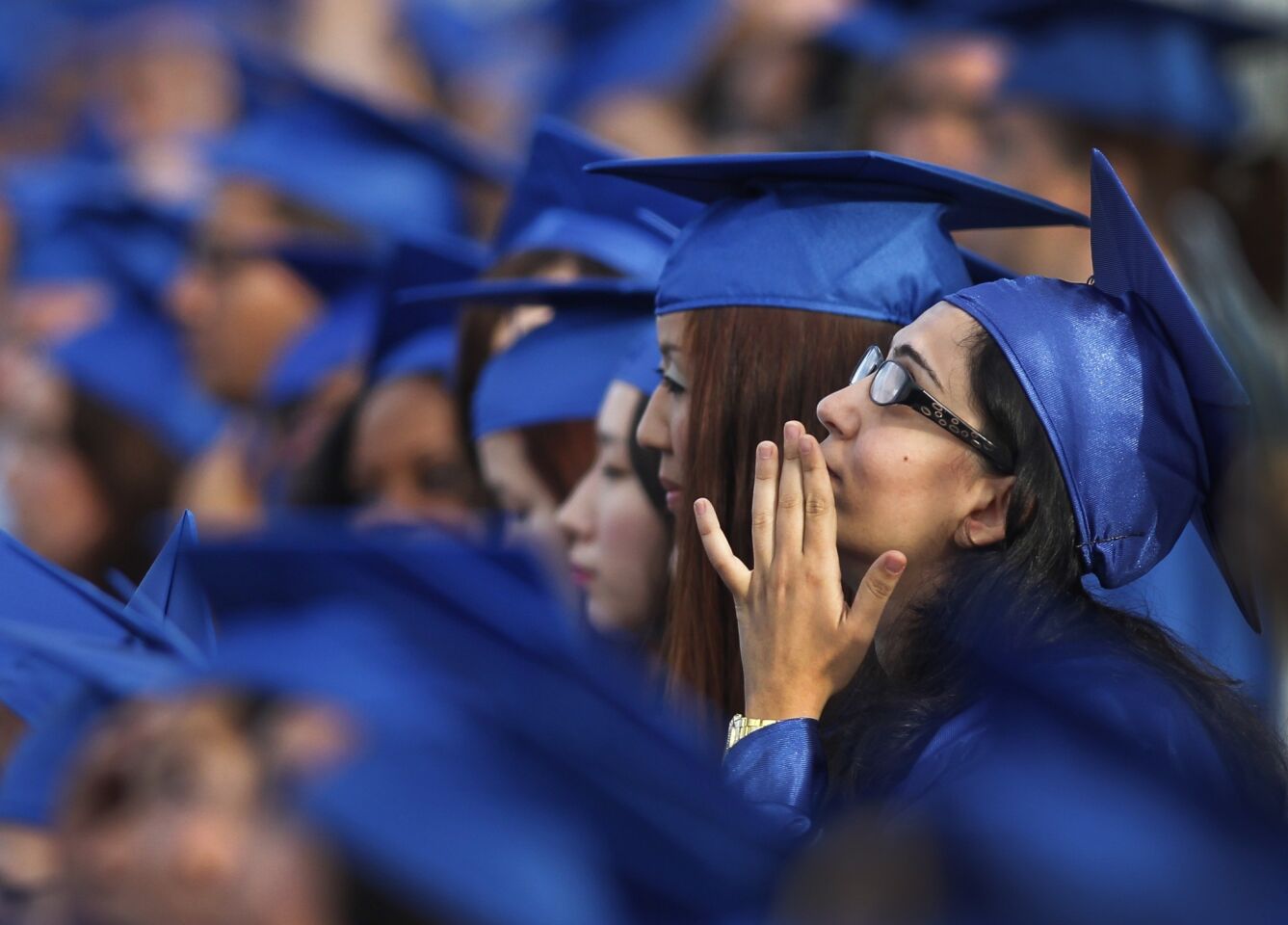 A Santa Monica College graduate listens to a speaker during the commencement ceremony Tuesday evening. Just about every speech made note of the recent violence in the city.