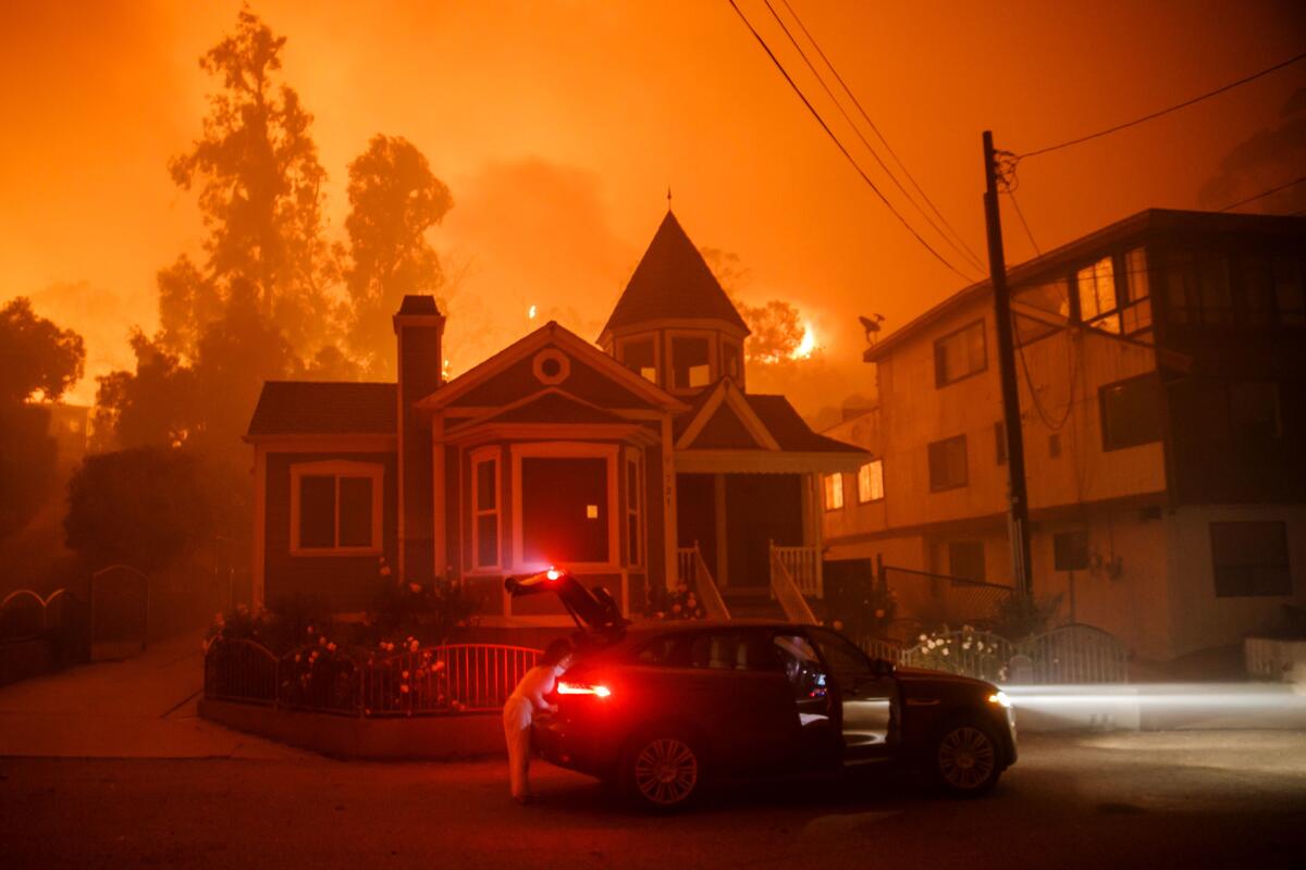 A family pack up and evacuate as a brushfire get closer to their home in Ventura, Calif., on Dec. 5, 2017.