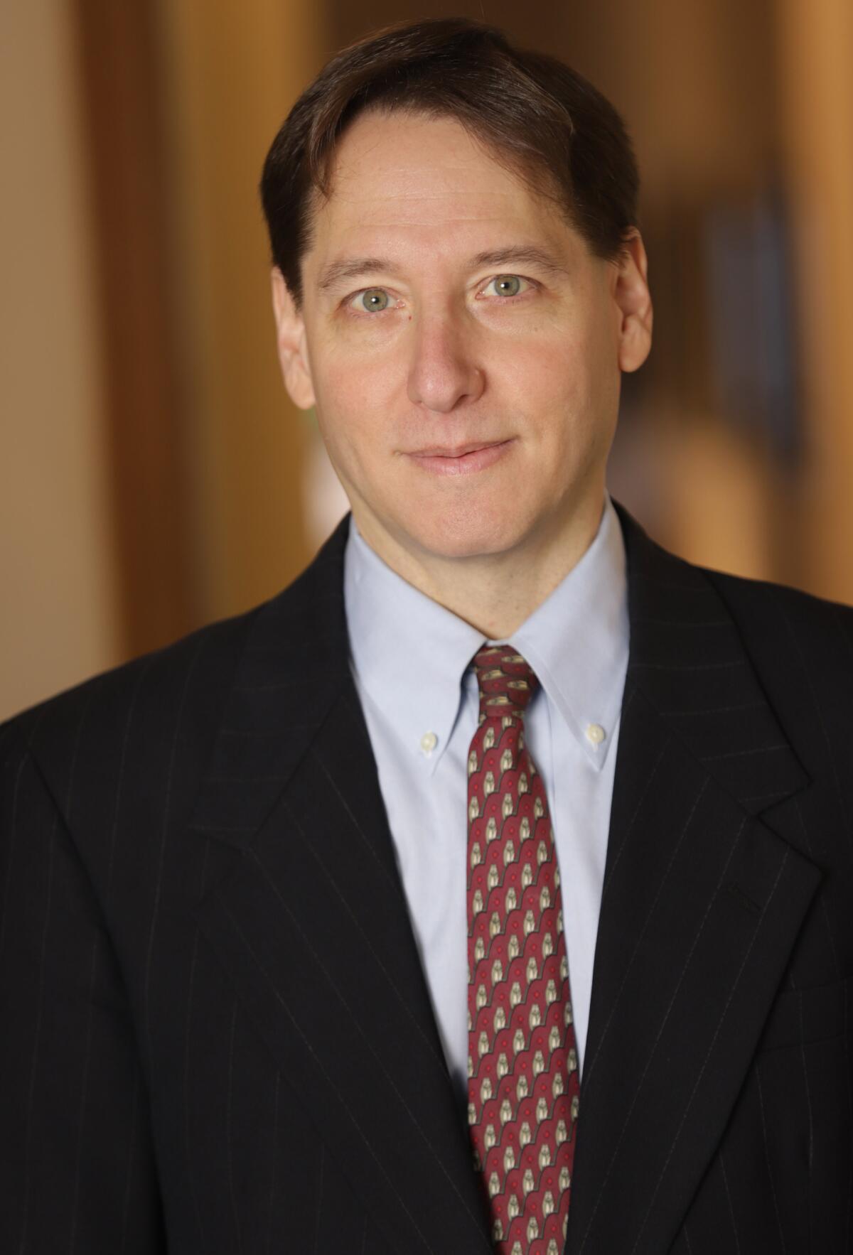 Jonathan Karp wears a suit in his headshot