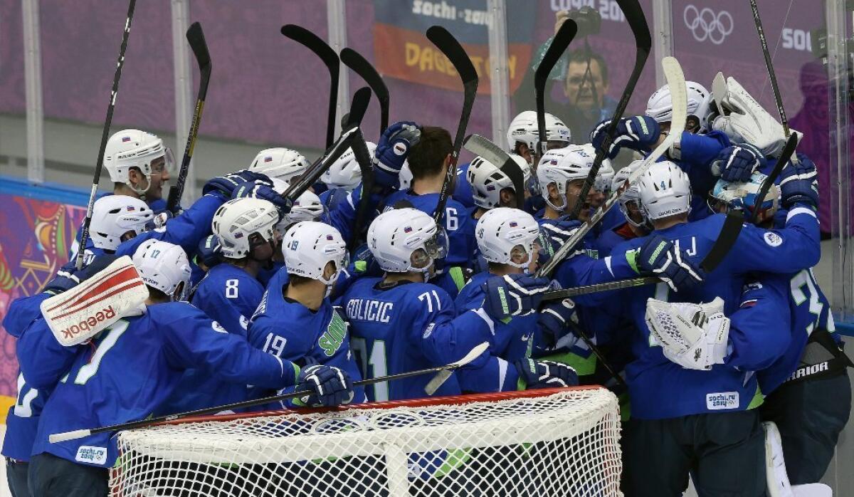 Team Slovenia celebrates its men's hockey playoff qualification round victory over Austria.