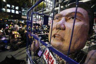 A caricature of Yoon Suk Yeol's head in a locked cage