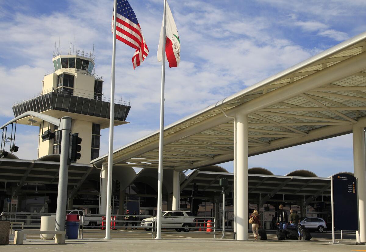 Travelers prepare to enter Oakland International Airport.