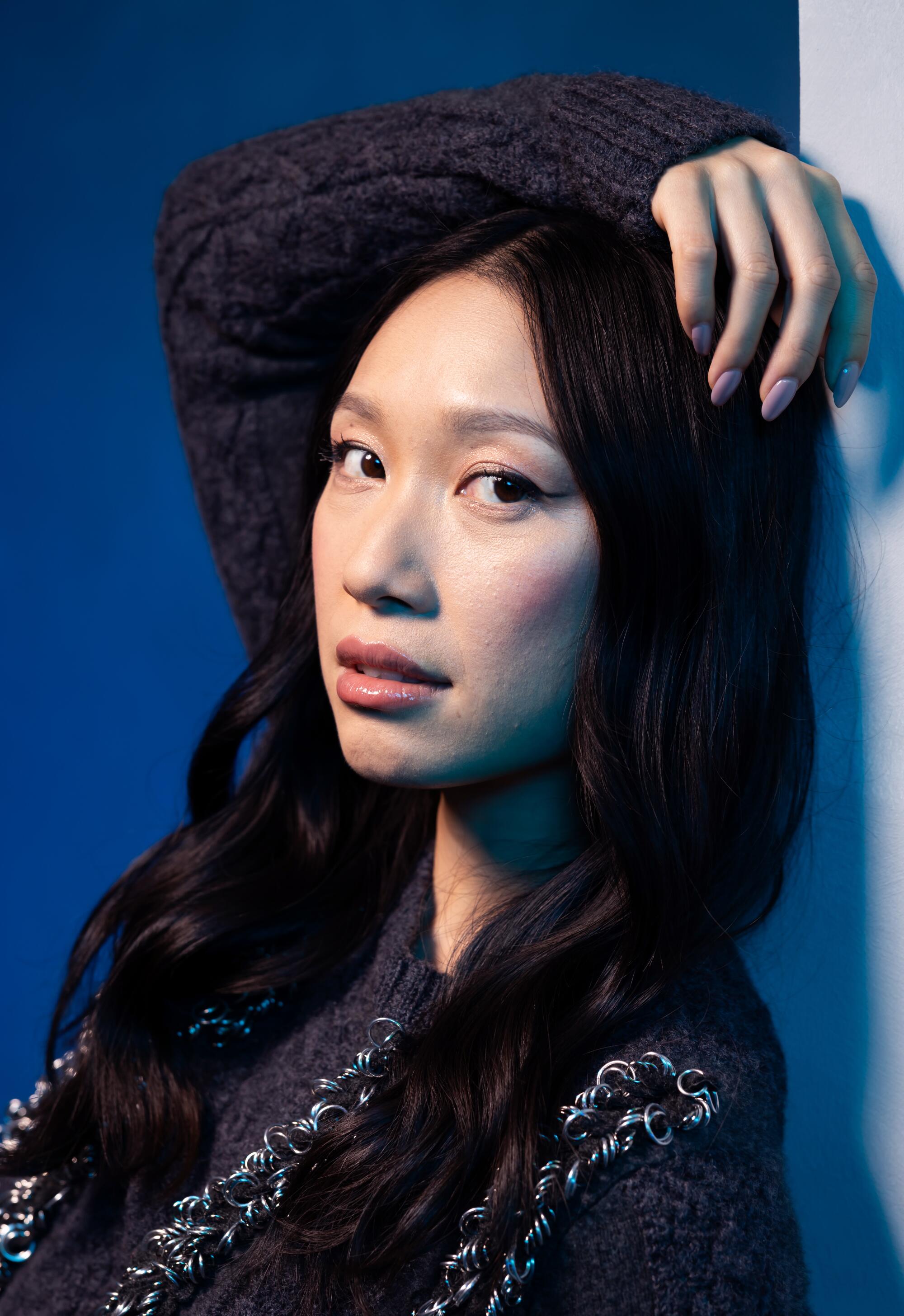 Jess Hong drapes an arm over head in a portrait.