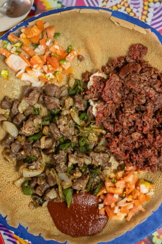 A blue plate loaded with Ethiopian food.