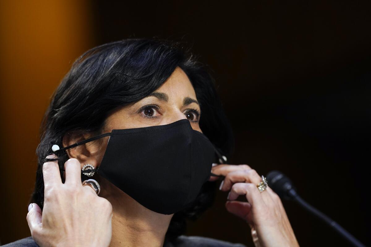Dr. Rochelle Walensky, director of the CDC, adjusts her face mask during a hearing on Capitol Hill. 