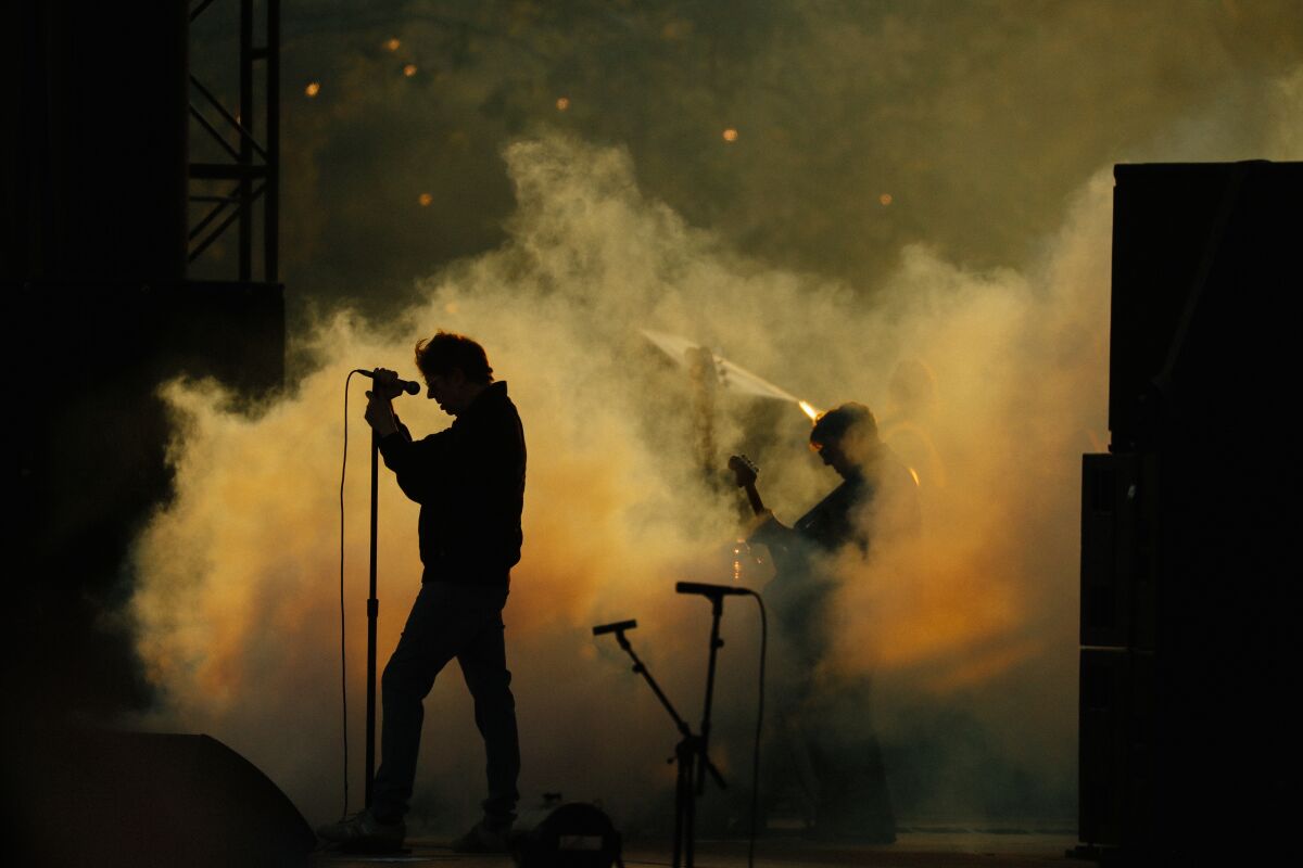 فرقة تؤدي على خشبة المسرح وسط سحب من الدخان.