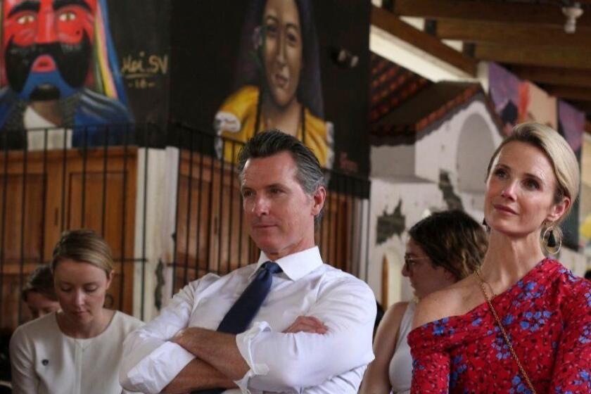 California Gov. Gavin Newsom and his wife, Jennifer Siebel Newsom, right, listen to a recital of violins by young Salvadorans who belong to a music academy in Panchimalco, El Salvador, Monday, April 8, 2019. (AP Photo/Salvador Melendez)