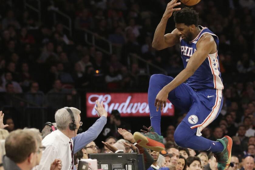Philadelphia 76ers' Joel Embiid leaps into the stands while chasing a loose ball during the second half of an NBA basketball game against the New York Knicks, Wednesday, Feb. 13, 2019, in New York. The 76ers won 126-111. (AP Photo/Frank Franklin II)