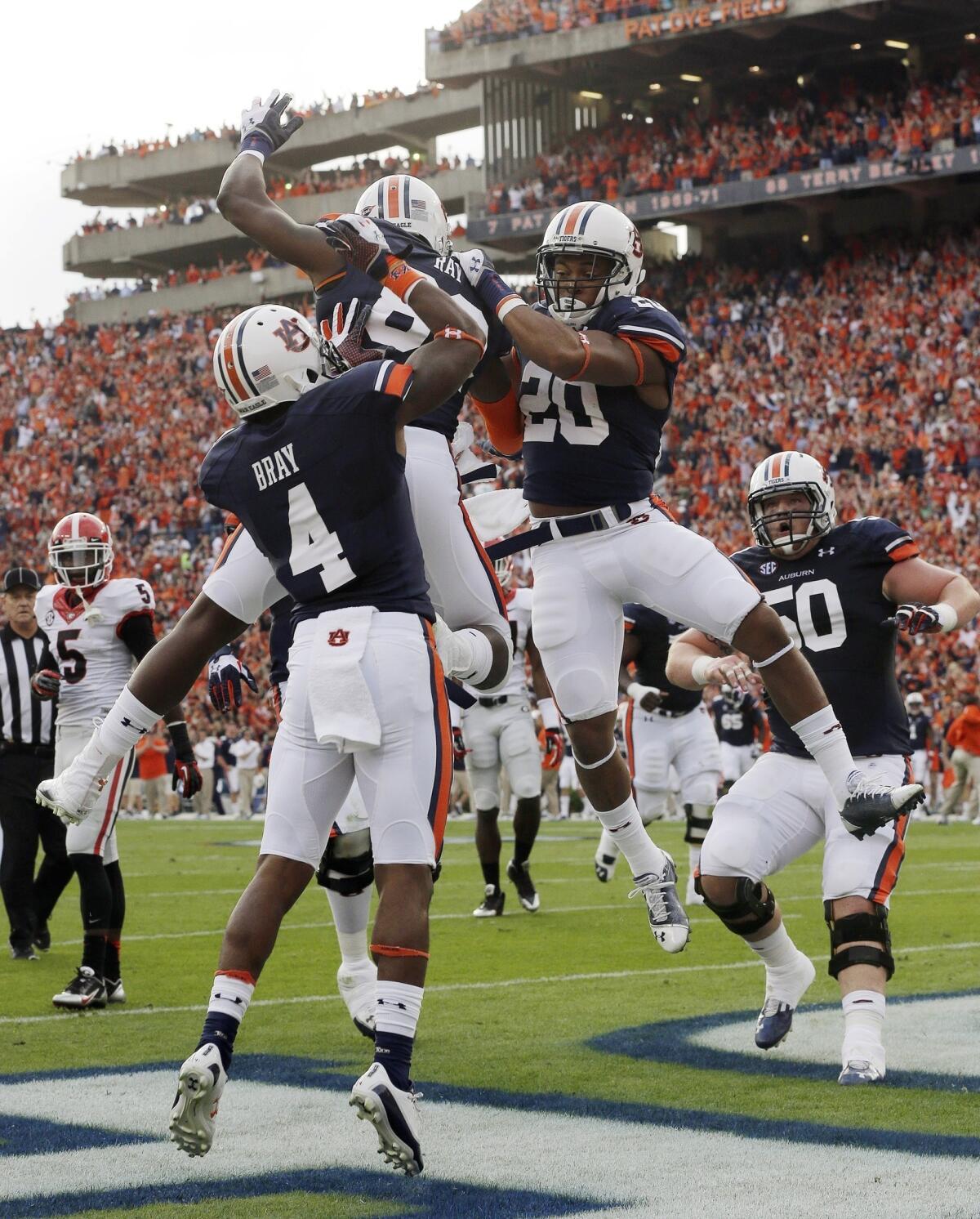 Auburn running back Corey Grant, right, celebrates with teammates Quan Bray, left, and Melvin Ray after scoring a touchdown in Saturday's 43-38 win over Georgia. The Tigers still have a chance of making the BCS title game heading into their showdown with top-ranked Alabama on Nov. 30.