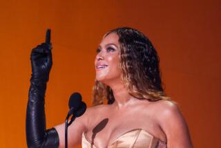 Beyoncé accepts a Grammy and points to the sky