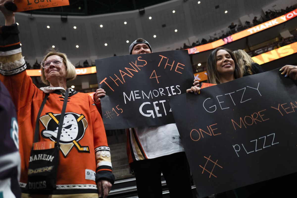 Fans hold signs for Ducks' Ryan Getzlaf before the team's game against the St. Louis Blues.