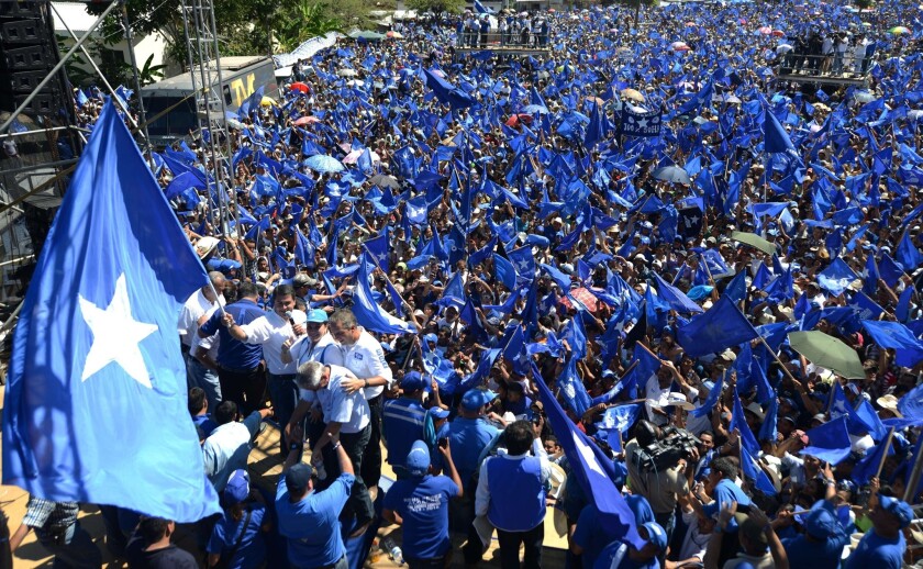 The president of the Honduran Congress and presidential candidate for the ruling Partido Nacional, Juan Orlando Hernandez holds a flag during a rally.