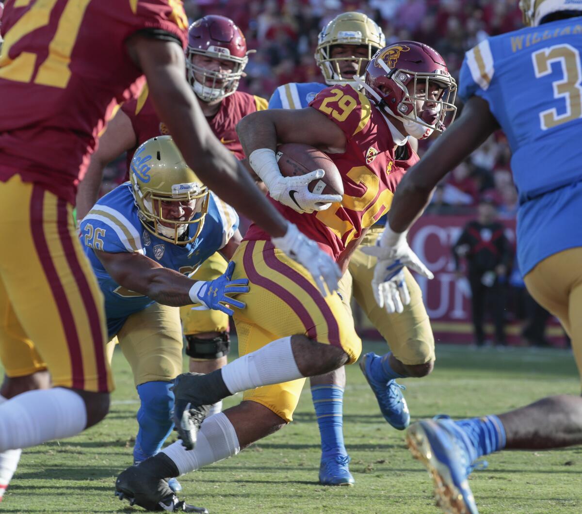 USC running back Vavae Malepeai (29) eludes the tackle of UCLA linebacker Leni Toailoa (26) for a touchdown run in the third quarter at the Coliseum on Saturday.