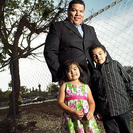Fred Reyes and his children Natalie, 4, and Nicholas, 7, stand in the vacant lot where his mother's home of nearly 40 years had stood before the city of Santa Ana acquired it and knocked it down. "You'd think by now something would have been done" with the land, Reyes said.