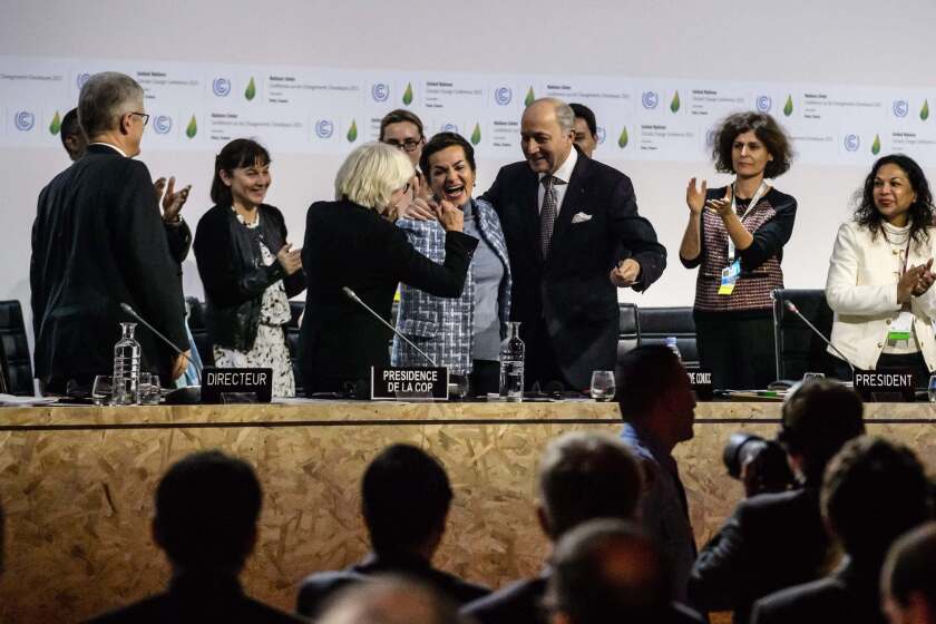 Paris climate conference representatives cheer after approval of the historic climate agreement on Saturday.