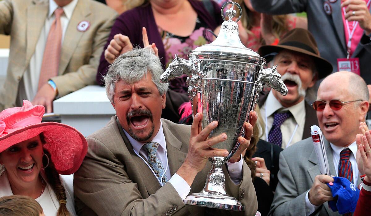 Trainer Steve Asmussen celebrates in the Winner's Circle after Untapable ran to victory in the 140th Kentucky Oaks on Friday at Churchill Downs.