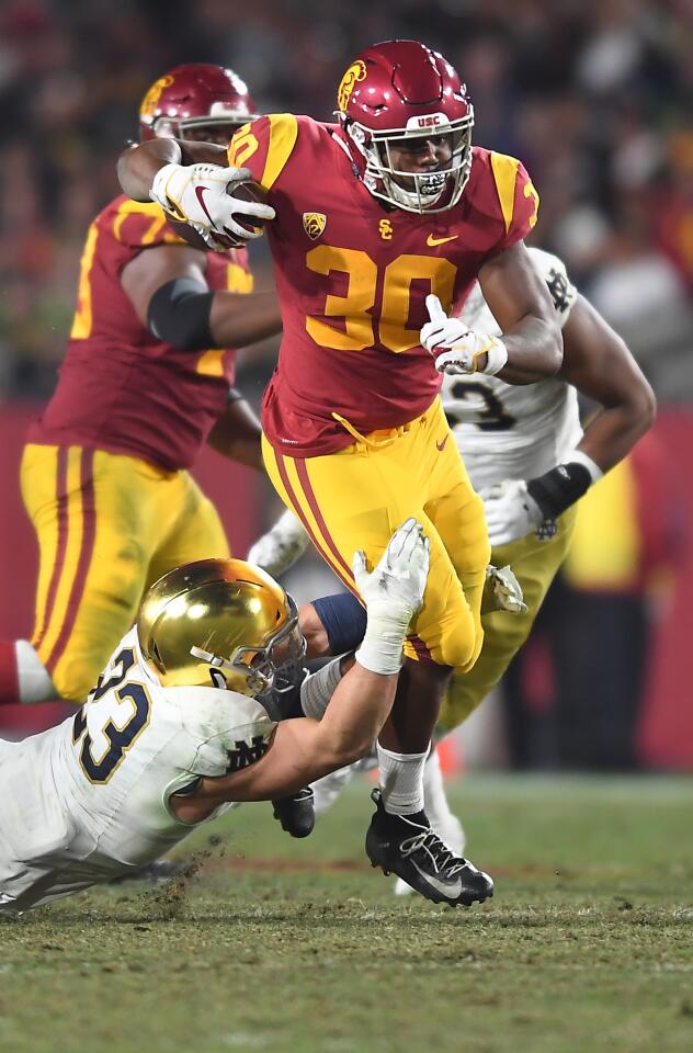 USC running back Markese Stepp tries to break a tackle by Notre Dame's Drue Tranquill at the Coliseum.