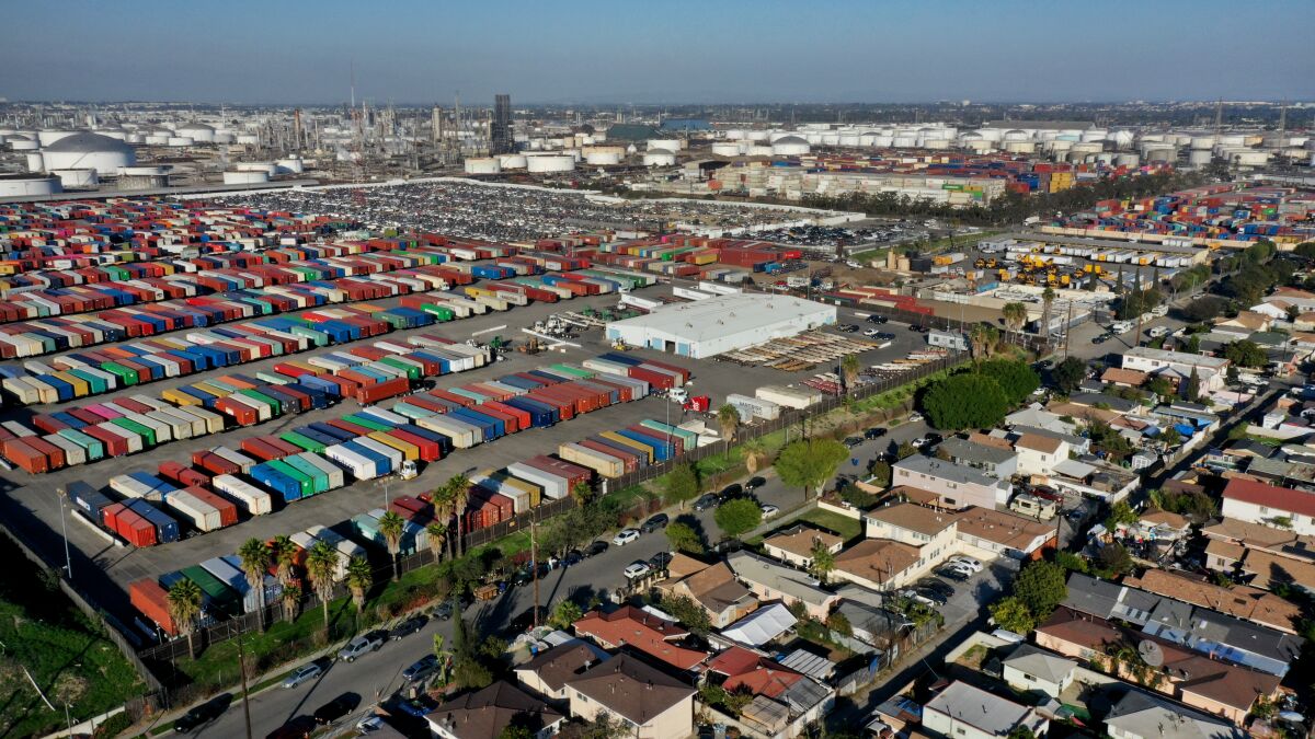 Containers are piled high north of E. Sandison Street, with houses on one side and containers on the other.