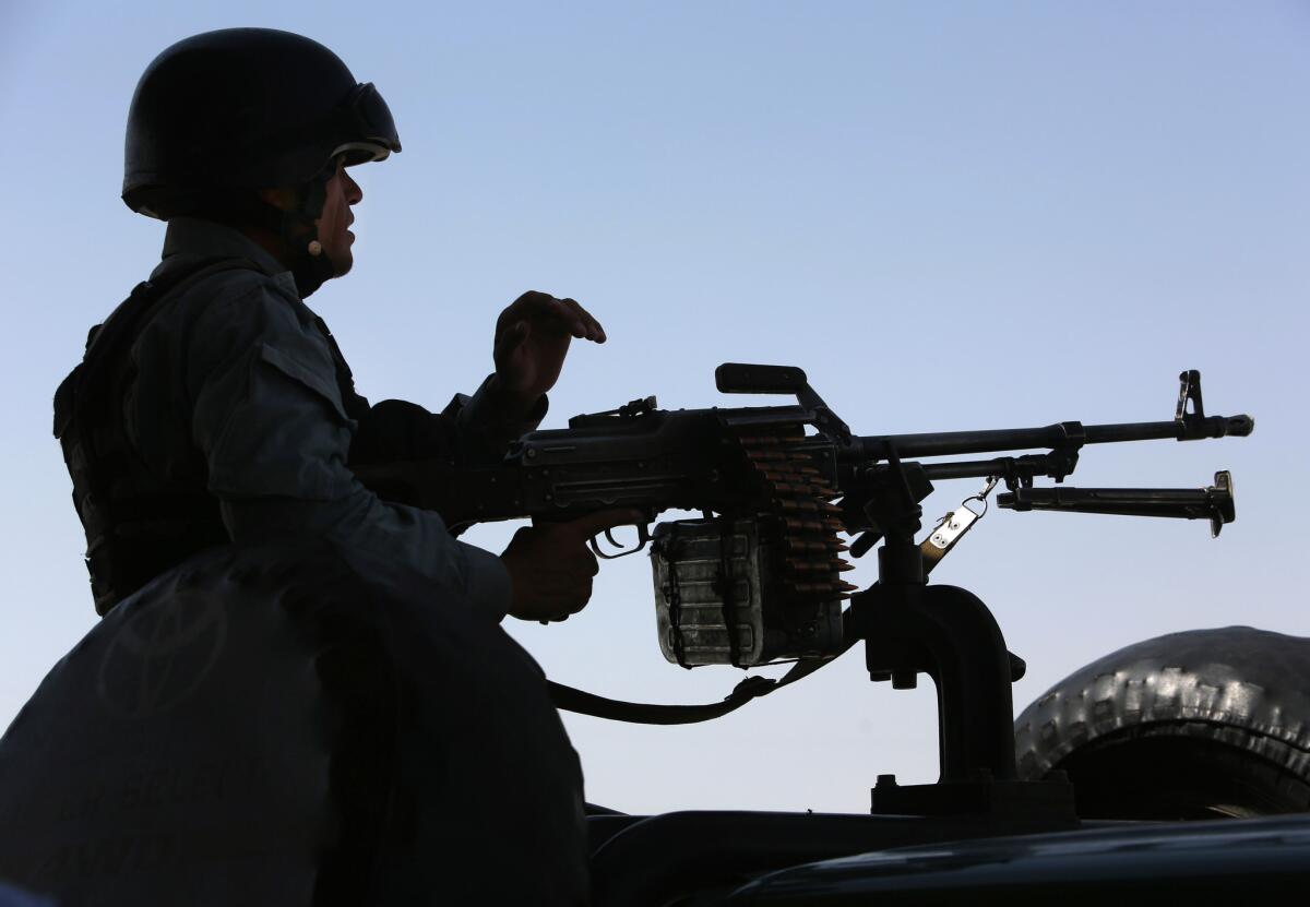An Afghan security officer holds his weapon at the site of a suicide attack after clashes with Taliban fighters in Kabul, Afghanistan, on July 7. Mullah Mohammad Omar, the leader of the Afghan Taliban, said peace talks between insurgents and the Afghan government were "legitimate."