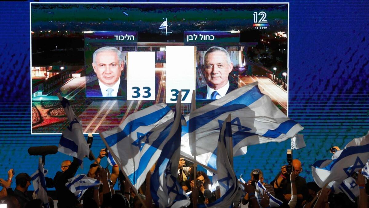 Supporters of the Benny Gantz's Blue and White party greet an early TV exit poll showing their party with a slight lead over Prime Minister Benjamin Netanyahu's Likud.