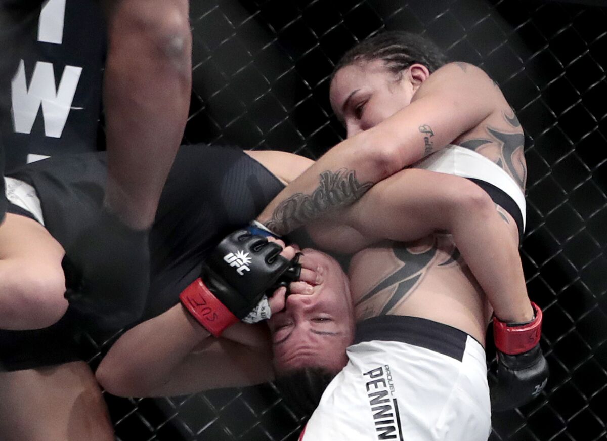Raquel Pennington, right, has Miesha Tate in a headlock during a bantamweight fight at UFC 205.