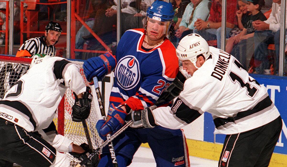 The Kings' Mike Donnelly, right, goes for the puck against Edmonton's Luke Richardson in 1994.