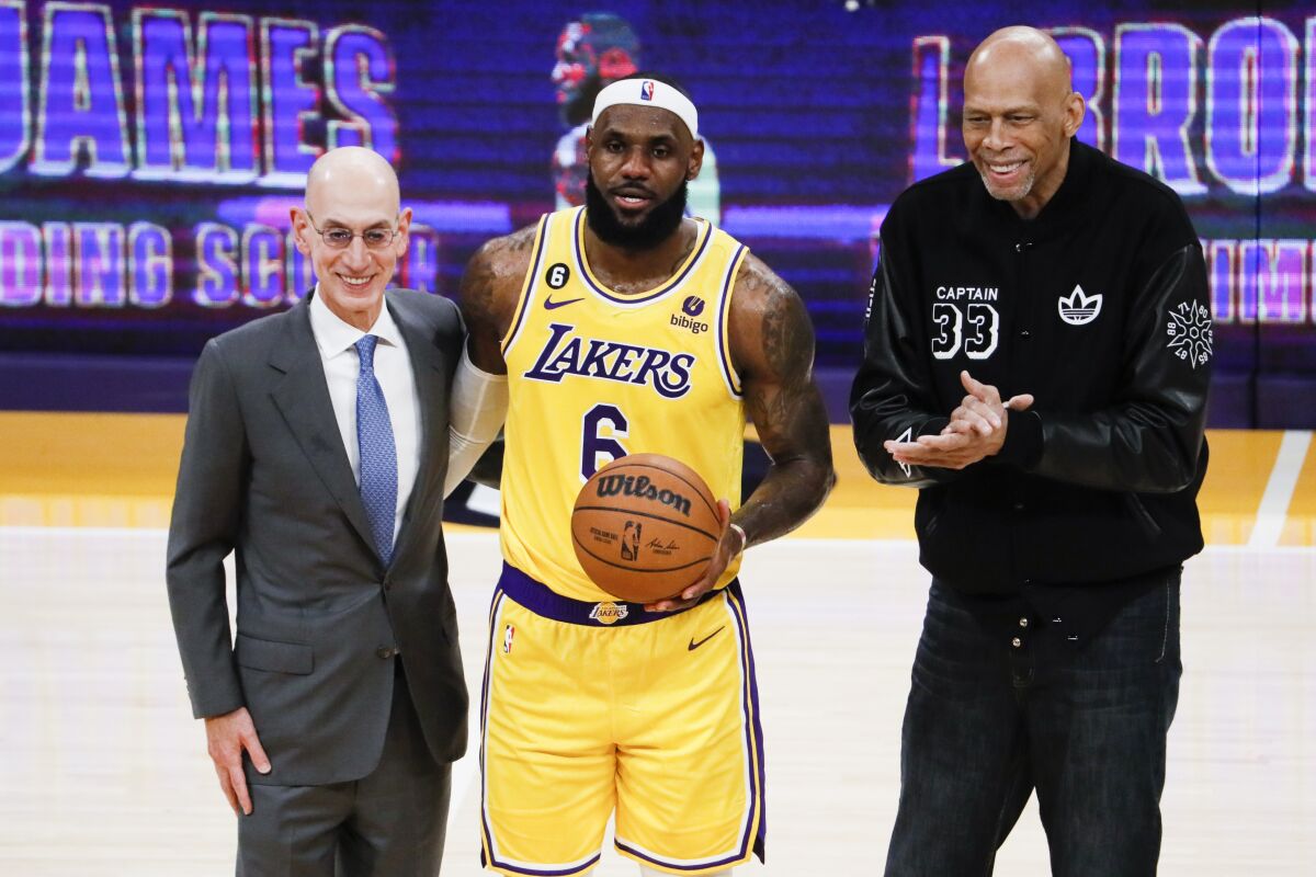 Lakers star LeBron James, center, poses with NBA Commissioner Adam Silver, left and Kareem Abdul-Jabbar.