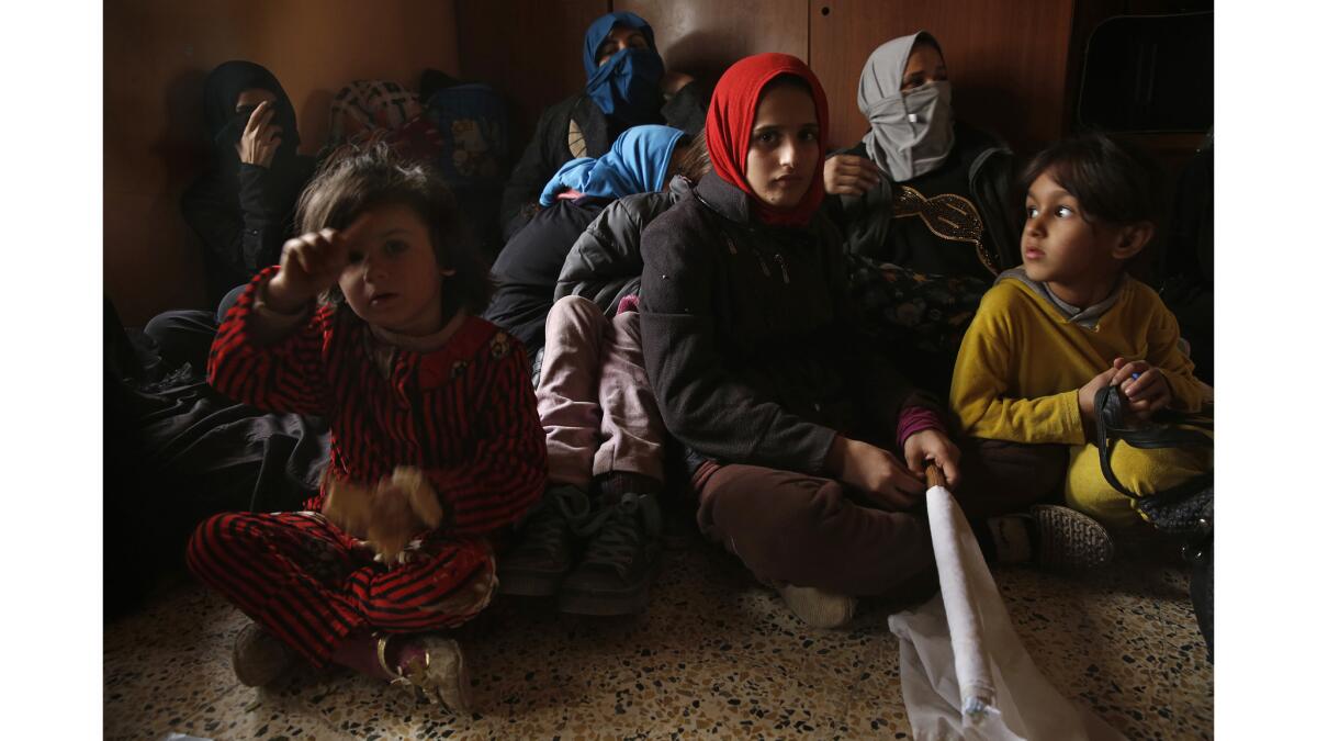Women and children who had just escaped the violence inside Mosul, by walking out, rest in a house before being transported to a displaced person's camp near Erbil, Iraq.