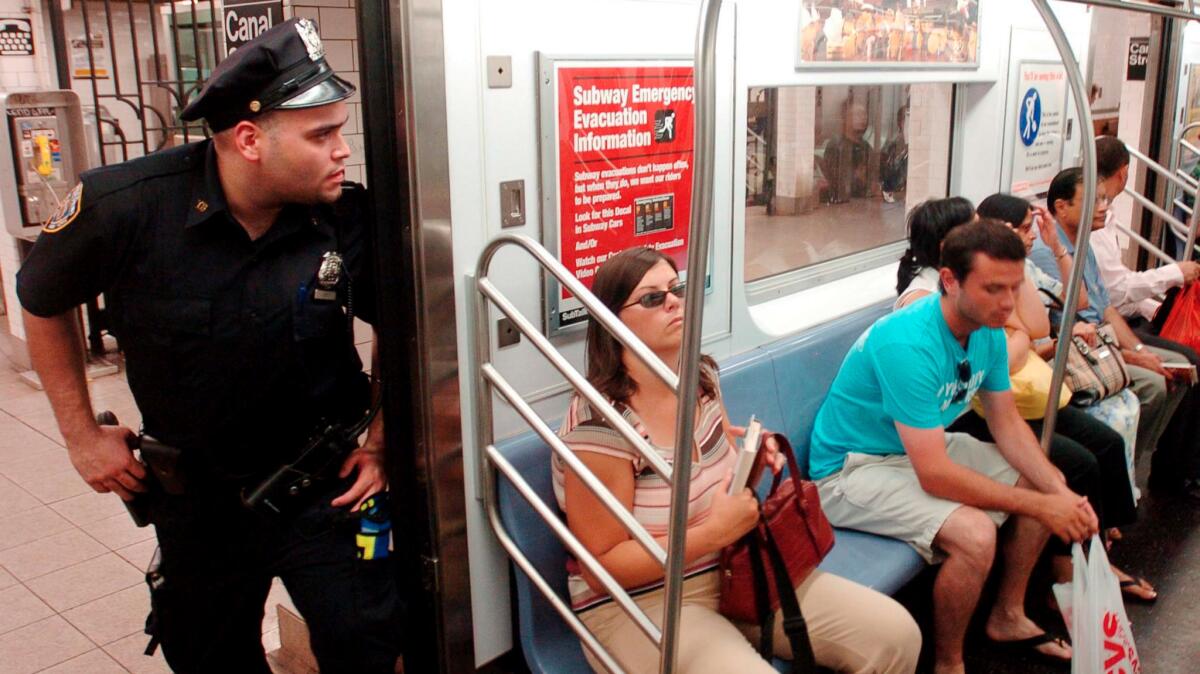 New York City police officer Edwin Soto looks into a subway car in July of 2005.