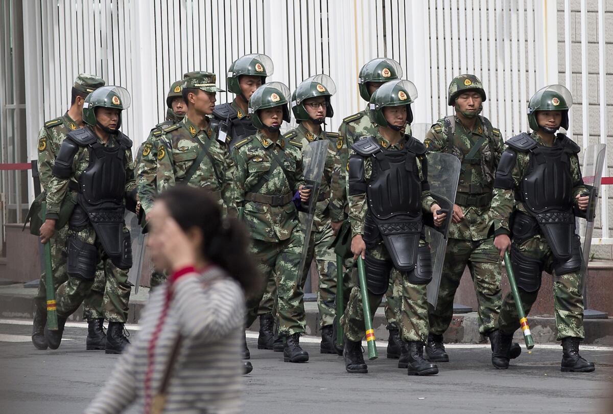Paramilitary police officers patrol near the People's Square in Urumqi, China, on Friday.